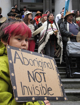 Indigenous child holding sign that reads Aboriginal, Not Invisible